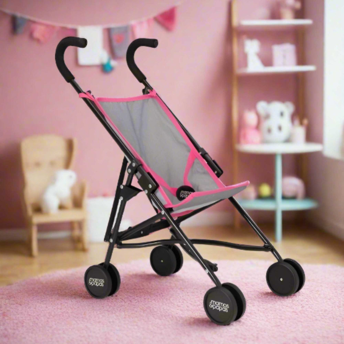 Mamas &amp; Papas Junior Doll Stroller in pink and grey, featuring a foldable and lightweight design for easy storage and portability, ideal for children&#39;s imaginative play with dolls.