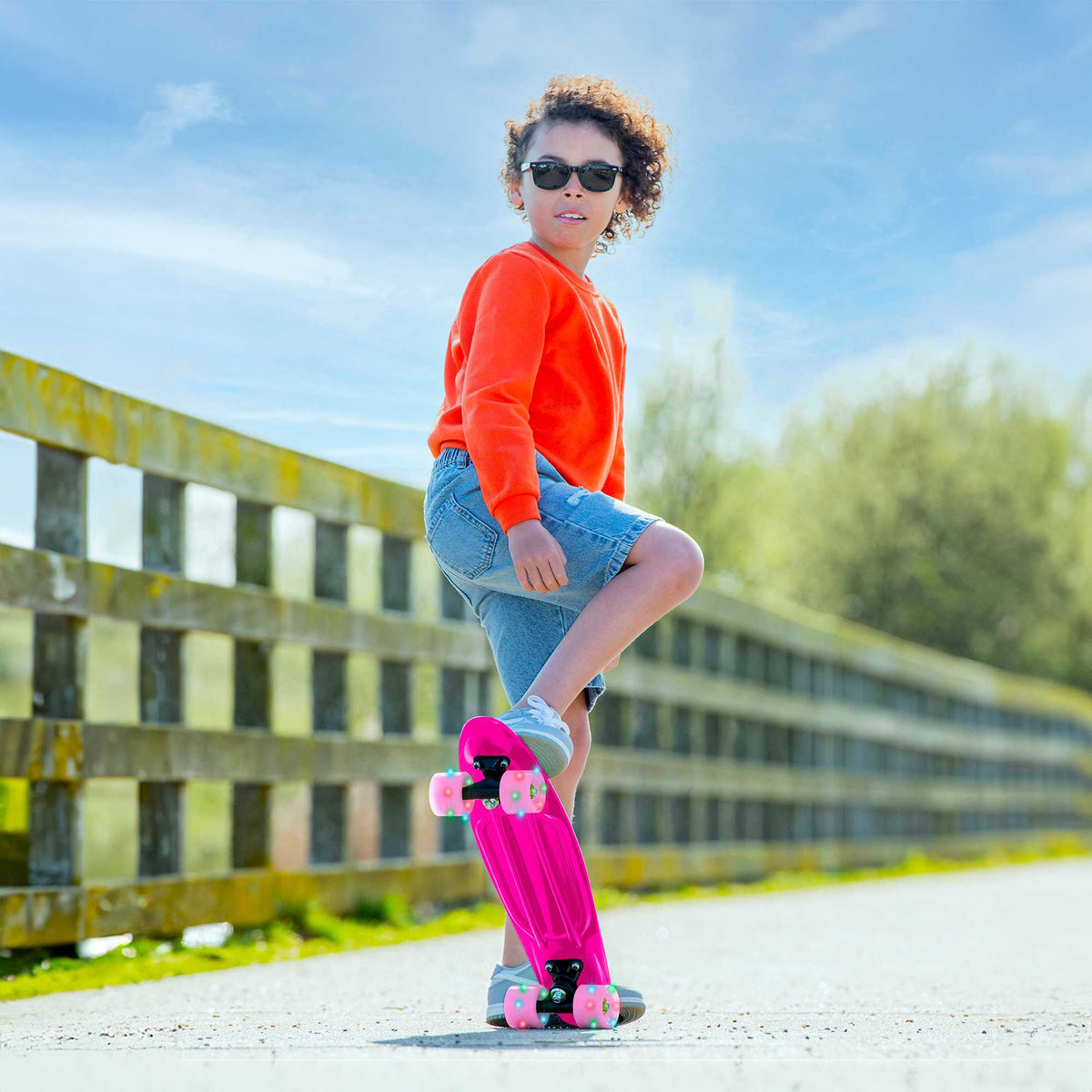 Children’s EVO 22-inch Penny Board in pink with light-up wheels, showcasing a compact design and vibrant retro style, perfect for young riders. The board features a textured grip surface and smooth, illuminated wheels that light up during movement.