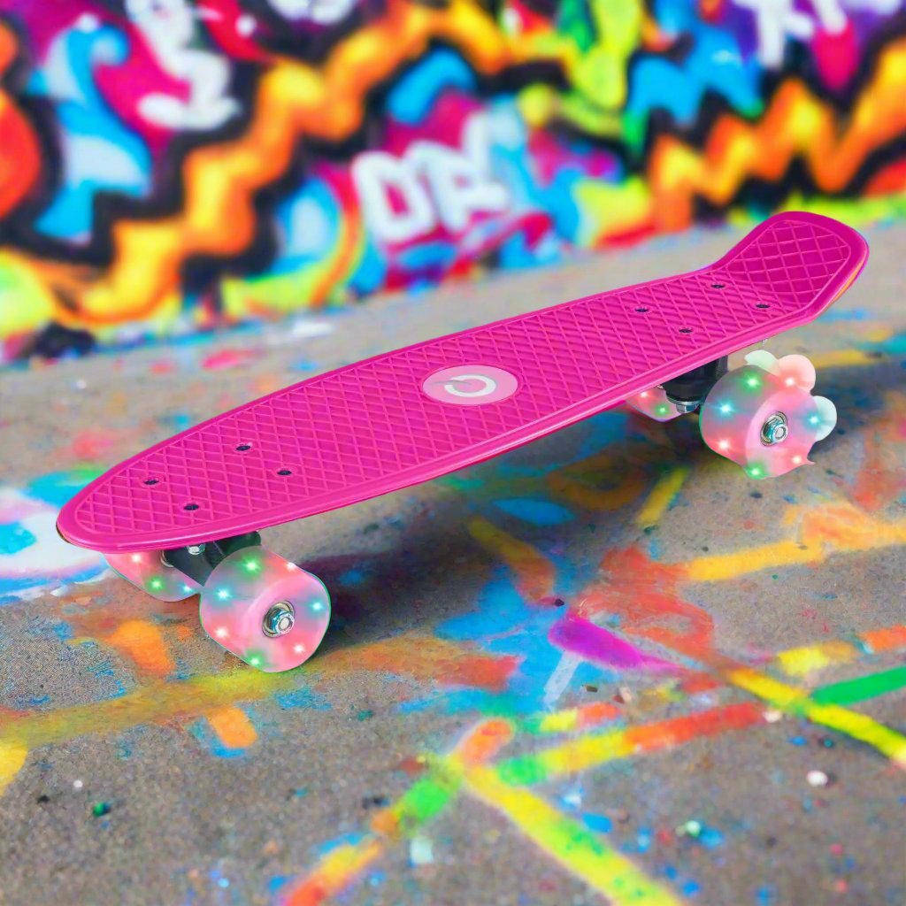 Children’s EVO 22-inch Penny Board in pink with light-up wheels, showcasing a compact design and vibrant retro style, perfect for young riders. The board features a textured grip surface and smooth, illuminated wheels that light up during movement.