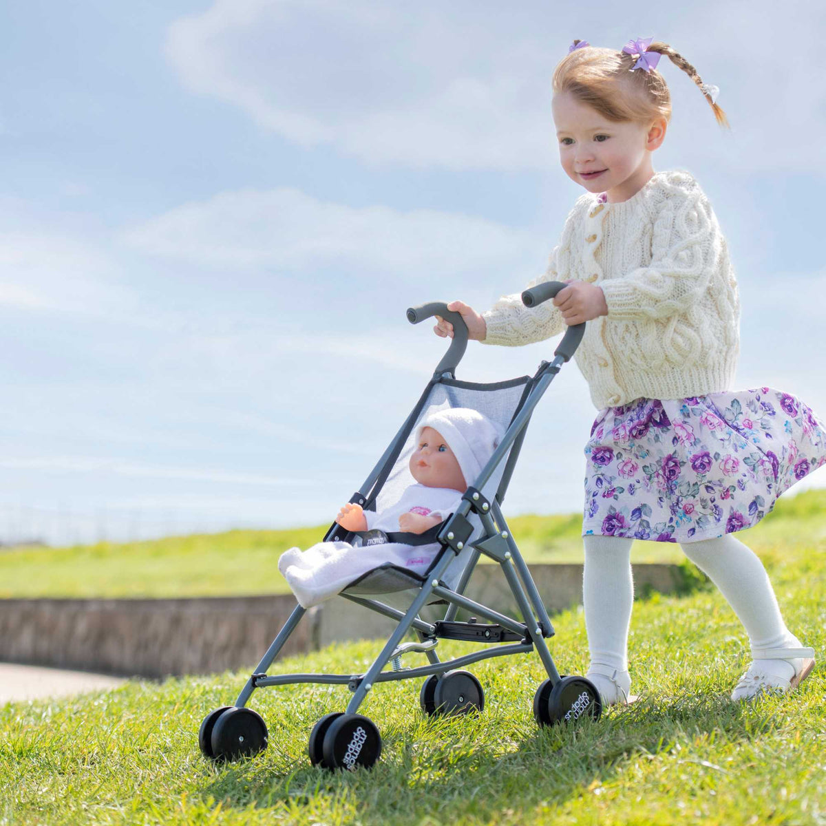 Mamas &amp; Papas Junior Doll Stroller in grey, featuring a foldable and lightweight design for easy storage and portability, ideal for children&#39;s imaginative play with dolls.