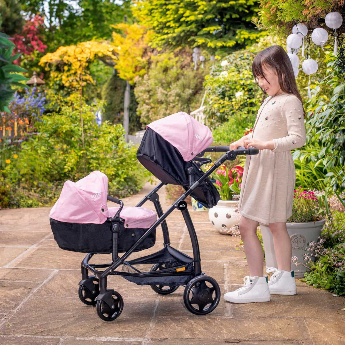 Joie Evalite Twin Dolls Pram with 9 play modes, featuring a stylish design in pink and black, adjustable handle height, swivel wheels, and a large storage basket, perfect for versatile and imaginative play with dolls.