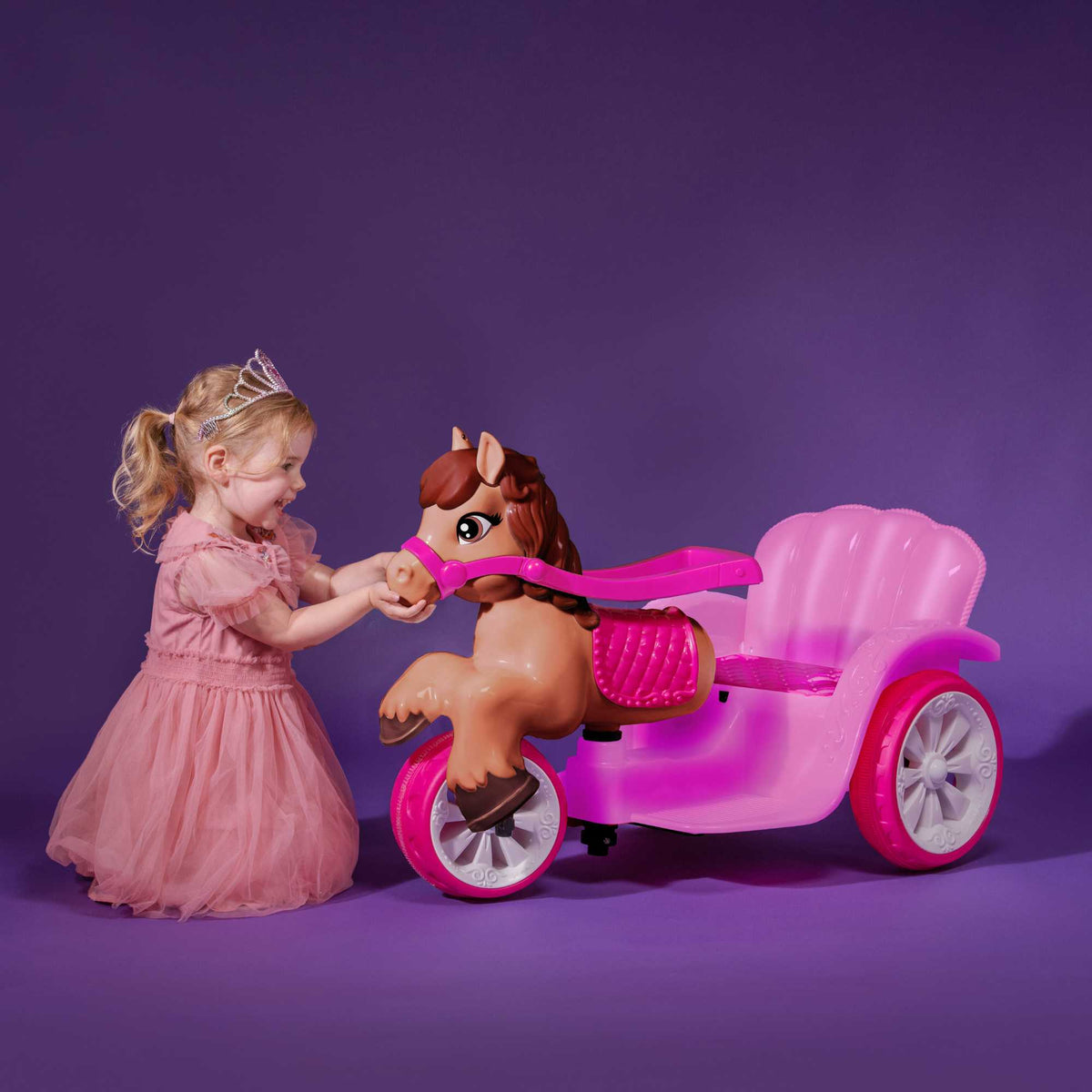 A whimsical EVO Electric Pony Carriage Ride-On Toy. The toy is shown in an outdoor garden setting, highlighting its enchanting design and sturdy construction.