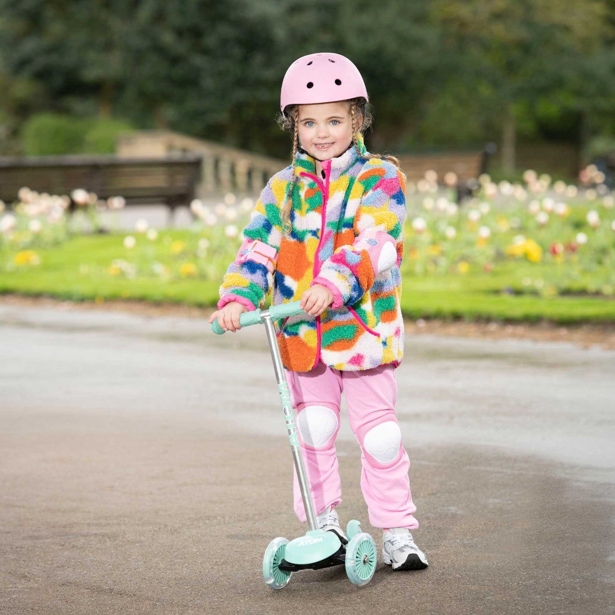 ATOM Move N Groove Light Up 3-wheeled scooter with flashing LED wheels, colourful design, and tilt to steer system, offering a fun and stable ride for children.