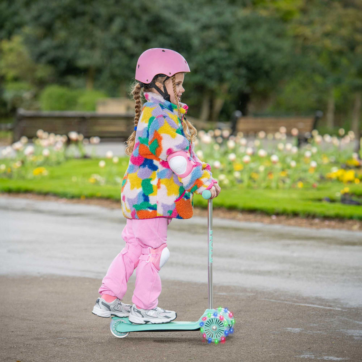 ATOM Move N Groove Light Up 3-wheeled scooter with flashing LED wheels, colourful design, and tilt to steer system, offering a fun and stable ride for children.