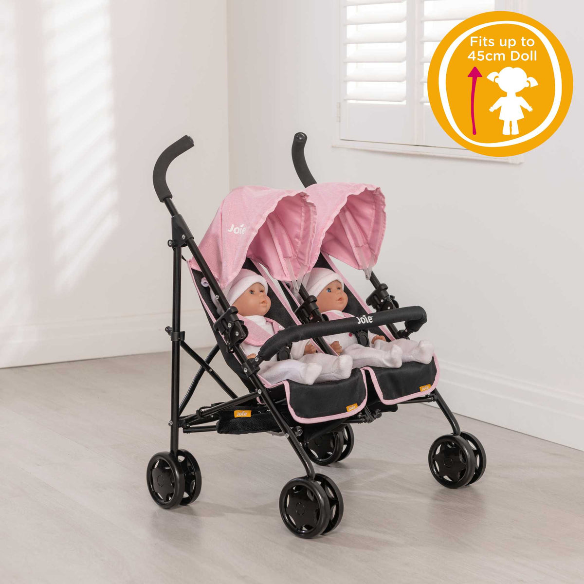 Joie Aire Twin Dolls Stroller in pink and black, designed with side-by-side seating for two dolls, adjustable handle height, swivel wheels, and a large storage basket, ideal for children to enjoy twin doll outings.