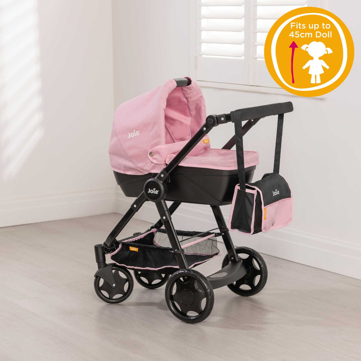 Joie Mytrax Dolls Pram in pink and black, featuring a realistic design with adjustable handle height, swivel wheels, and a large storage basket, ideal for children to take their dolls on walks and play pretend.