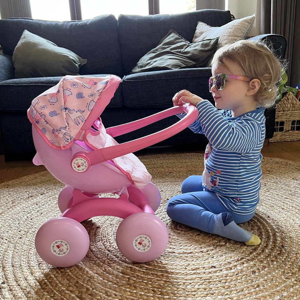 A child pushing the Peppa Pig 4-in-1 Pram with a doll inside, styled as a front-facing pushchair. The light pink body and Peppa Pig details enhance imaginative play.