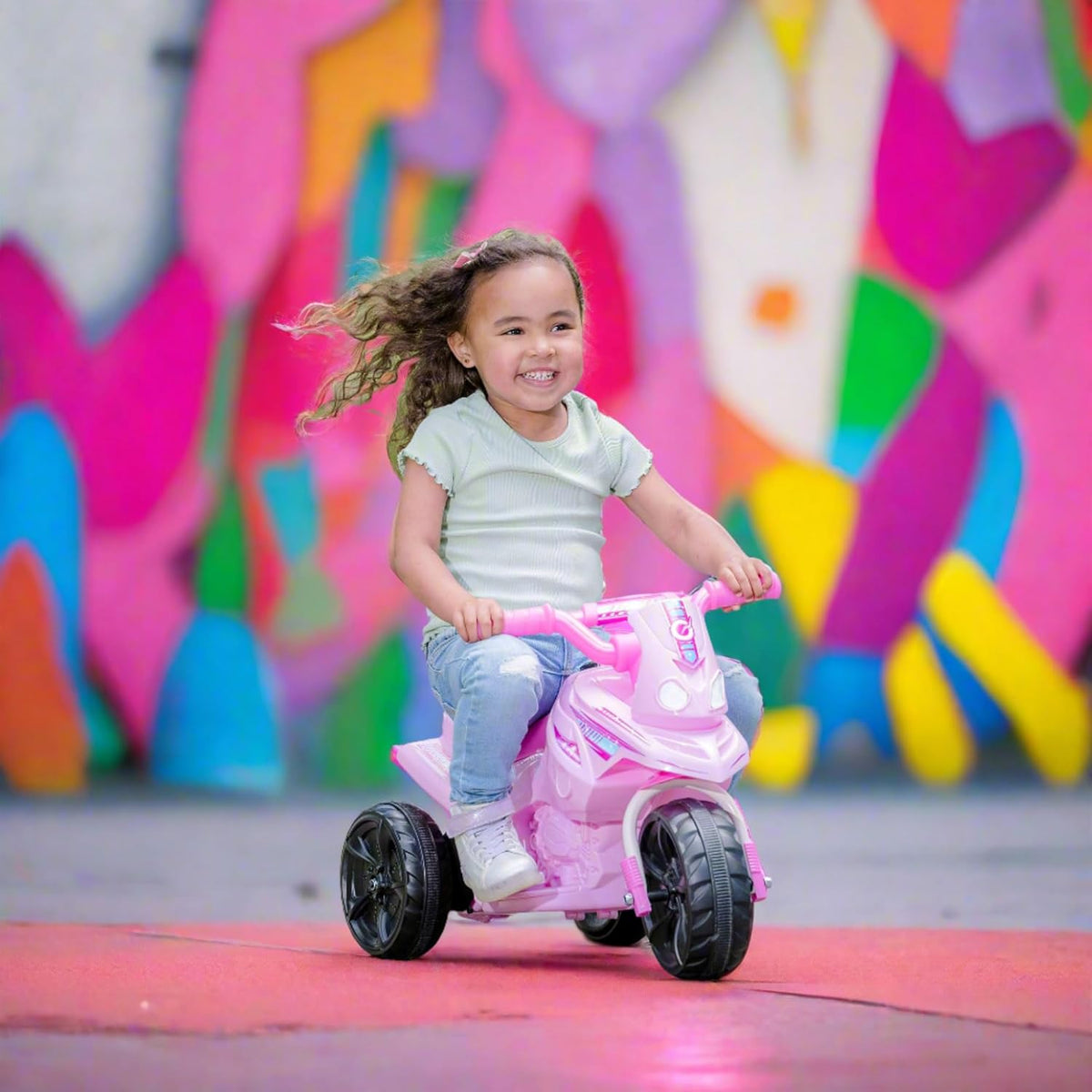 Electric pink EVO Shimmer Trike Ride-On for 2-year-olds, featuring a stable three-wheel design, ergonomic seat, and push-button acceleration for safe and exciting outdoor adventures.