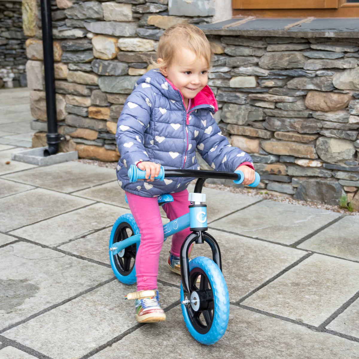 Child riding the EVO Balance Bike outdoors, showcasing the lightweight and durable design perfect for young learners to develop their balance and coordination skills