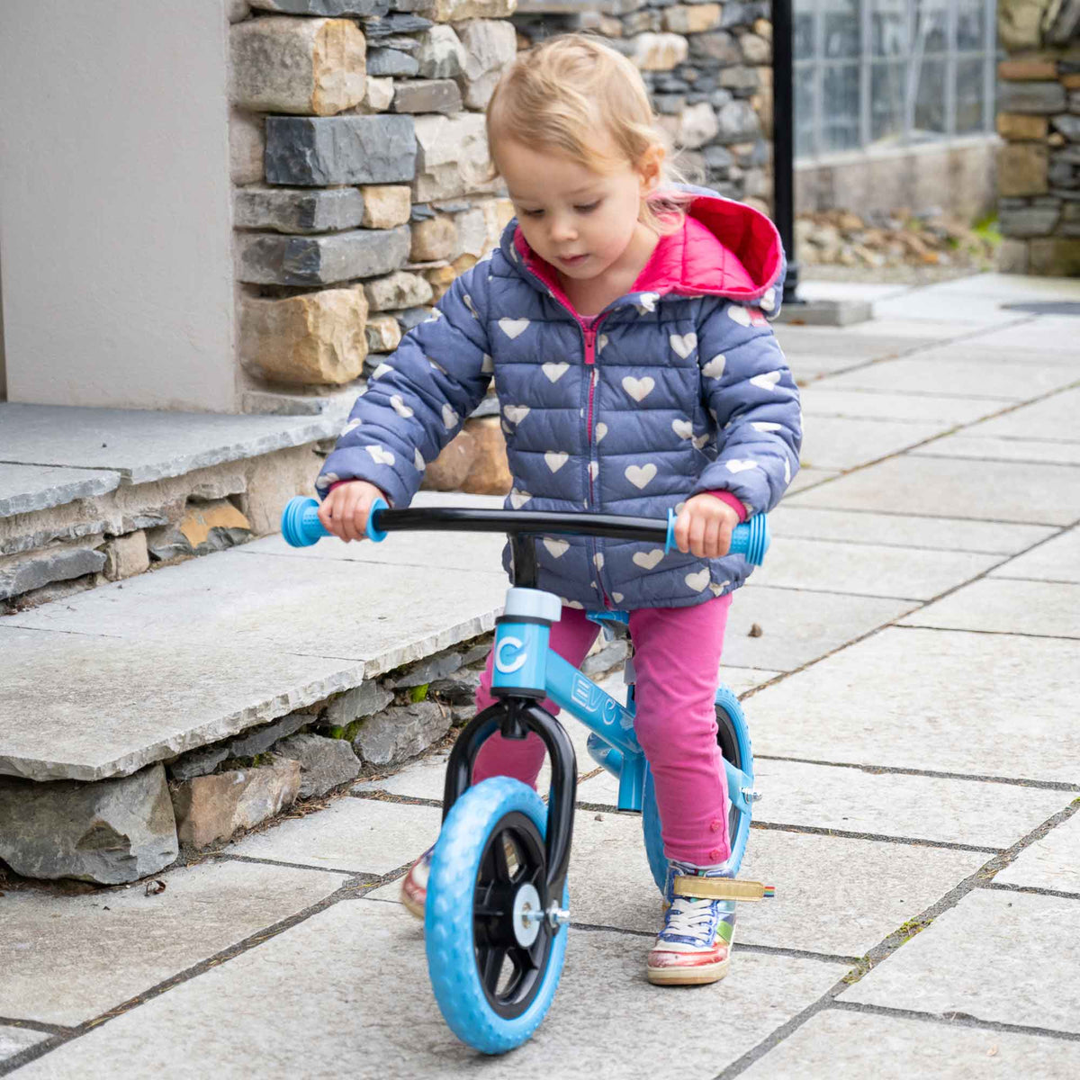 Child riding the EVO Balance Bike outdoors, showcasing the lightweight and durable design perfect for young learners to develop their balance and coordination skills