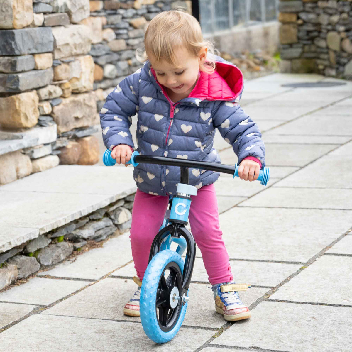 Child riding the EVO Balance Bike outdoors, showcasing the lightweight and durable design perfect for young learners to develop their balance and coordination skills