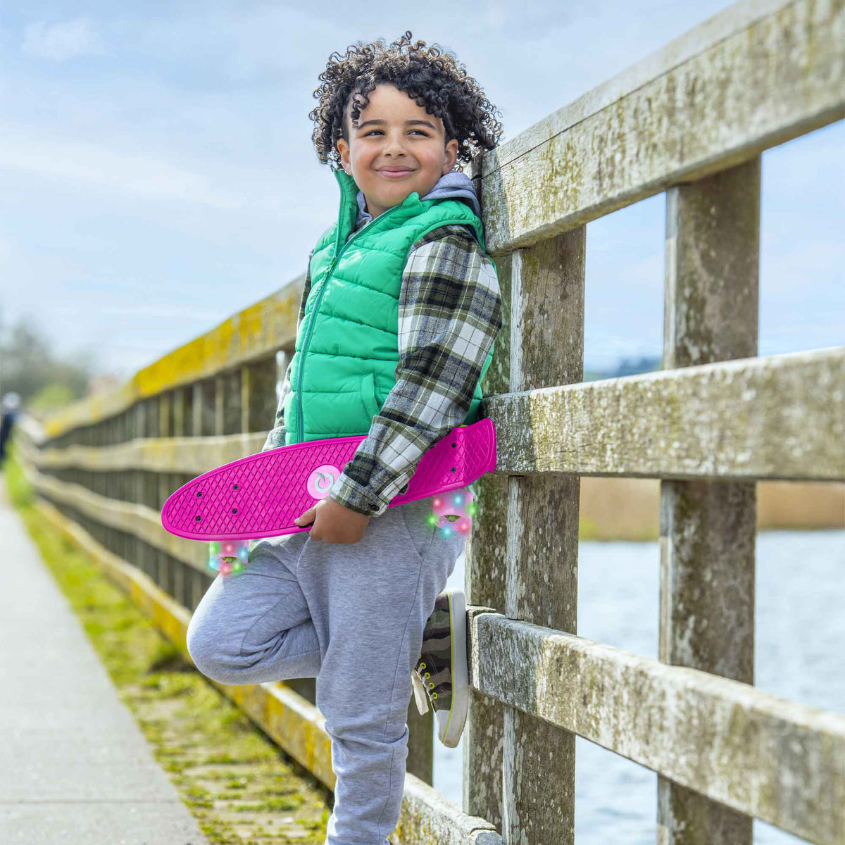 Children’s EVO 22-inch Penny Board in pink with light-up wheels, showcasing a compact design and vibrant retro style, perfect for young riders. The board features a textured grip surface and smooth, illuminated wheels that light up during movement.