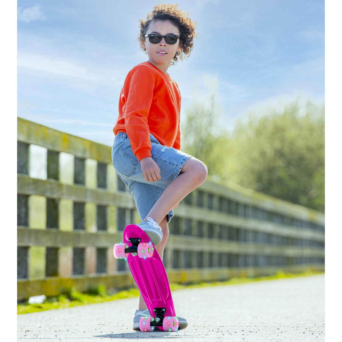 Children’s EVO 22-inch Penny Board in pink with light-up wheels, showcasing a compact design and vibrant retro style, perfect for young riders. The board features a textured grip surface and smooth, illuminated wheels that light up during movement.