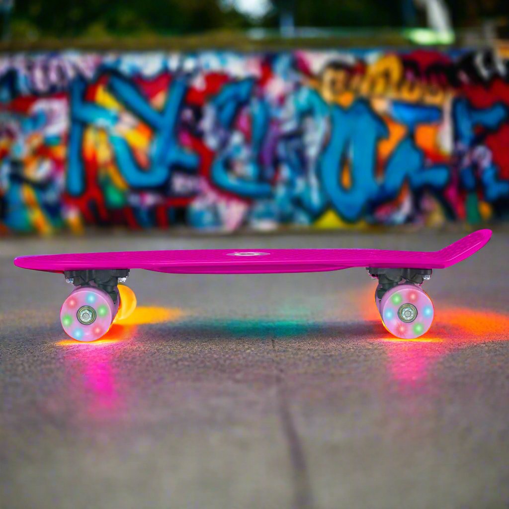 Children’s EVO 22-inch Penny Board in pink with light-up wheels, showcasing a compact design and vibrant retro style, perfect for young riders. The board features a textured grip surface and smooth, illuminated wheels that light up during movement.